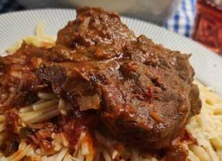 Κοκκινιστό Μοσχάρι με Μακαρόνια σε πιάτο, με τριμμένο τυρί και πλούσια σάλτσα.