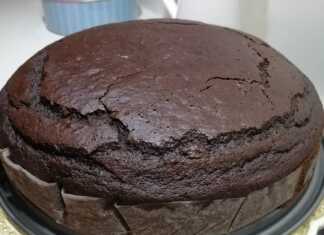 Μια λαχταριστή σοκολατόπιτα κομμένη σε κομμάτια μέσα στο ταψί με έντονο σοκολατένιο χρώμα και άρωμα πορτοκαλιού