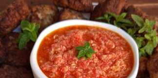 Τηγανητοί κεφτέδες σερβιρισμένοι δίπλα σε πικάντικη στραπατσάδα με ντομάτα και πιπεριά.