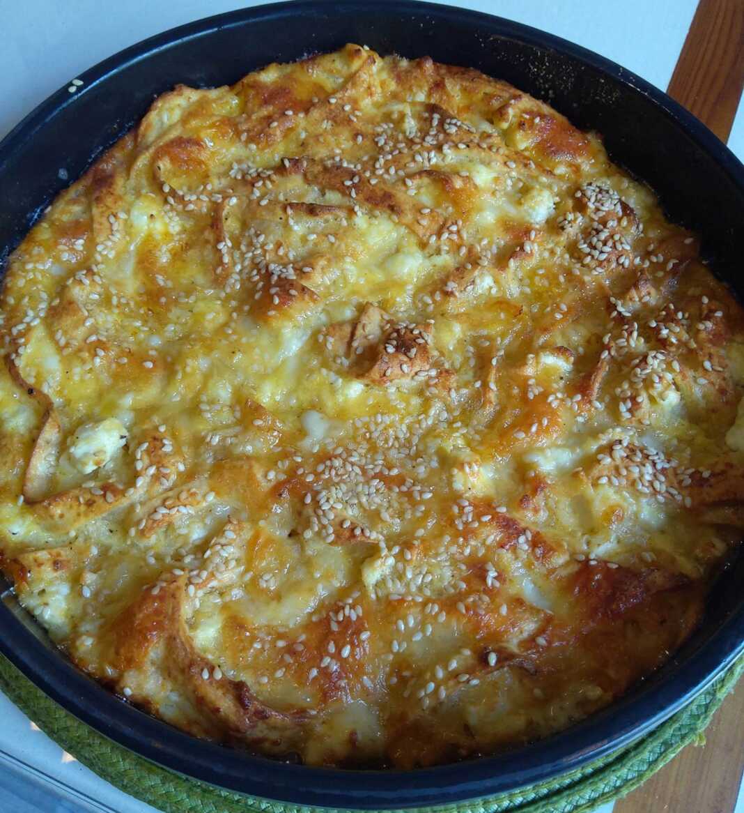 Ζουμερή ψευτόπιτα με τορτίγιες και τυριά, φρεσκοψημένη σε ταψάκι.