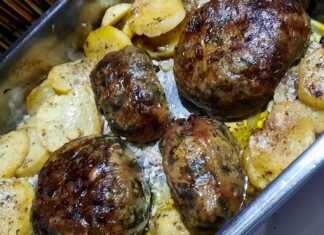 Τζιγεροσαρμάδες ψημένοι σε ταψί με πατάτες, λαμπεροί από την επάλειψη με αυγό, πασπαλισμένοι με φρέσκα μυρωδικά.