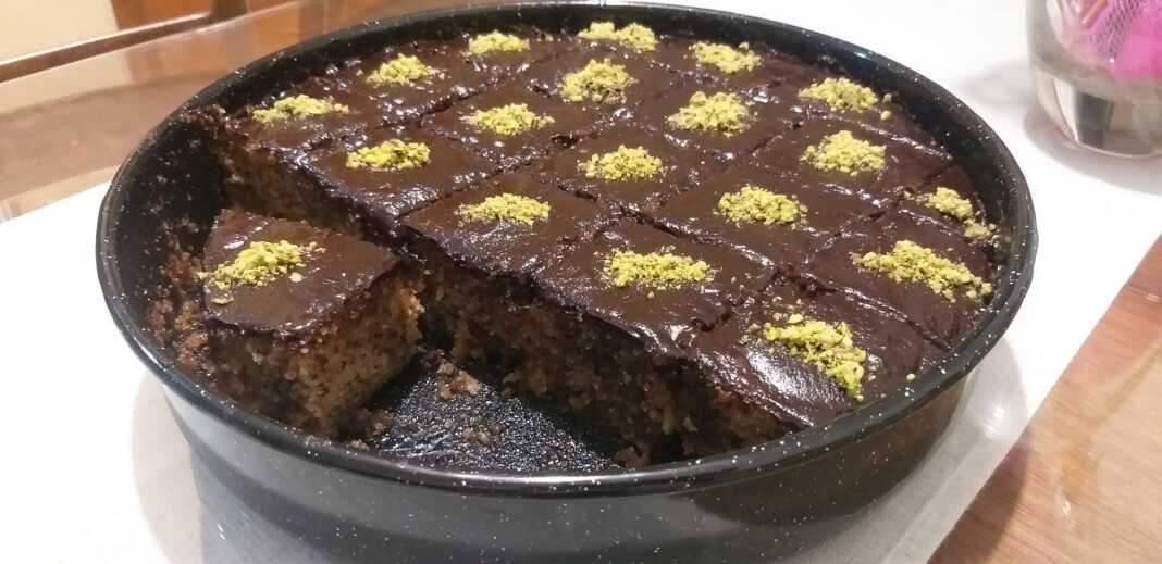 karidopita sokolata Ενα κομμάτι ή ολόκληρο κέικ καρυδόπιτα με επικάλυψη ή κομμάτια σοκολάτας.