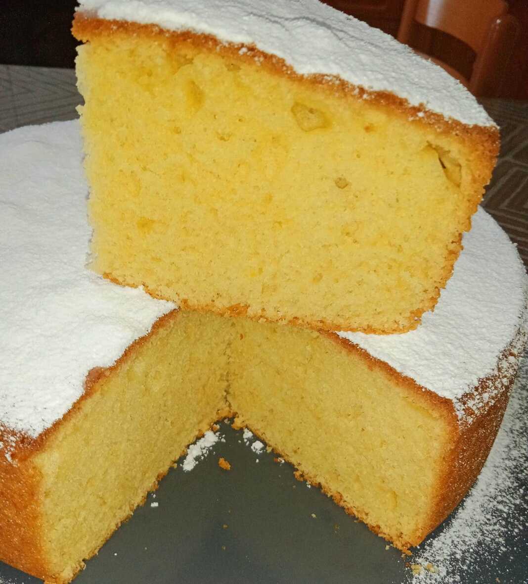 keik Lemoni Ένα κομμάτι από το Αφράτο Κέικ Λεμονιού με Γιαούρτι, πασπαλισμένο με άχνη ζάχαρη.