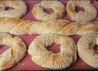 Στριφτά κουλούρια Θεσσαλονίκης με άφθονο σουσάμι, σερβιρισμένα σε ξύλινη επιφάνεια.