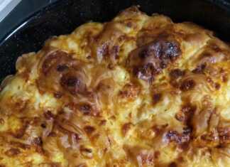 Παραδοσιακή βασιλόπιτα τυρόπιτα με σπιτικό φύλλο, κομμένη σε κομμάτια, με χρυσαφένια κρούστα.