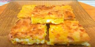 Παραδοσιακή ζυμαρόπιτα (αλευρόπιτα) με φέτα, κομμένη σε κομμάτια, με χρυσαφένια, τραγανή κρούστα.