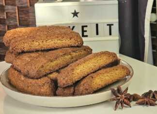 Τραγανά χρυσαφένια Νηστίσιμα Παξιμαδάκια Λαδιού αραδιασμένα πάνω σε λαδόκολλα, αναδύοντας αρώματα γλυκάνισου και πορτοκαλιού