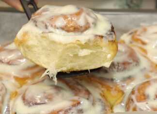 Αφράτα ρολάκια κανέλας cinnamon rolls μόλις βγαλμένα από τον φούρνο καλυμμένα με λευκό γλάσο τυριού κρέμας