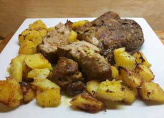 Μεγάλο κομμάτι χοιρινό κρέας με χρυσαφένια κρούστα, τοποθετημένο σε ταψί με αρωματικές, τραγανές ψητές πατάτες