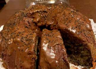 Ένα ψηλό και αφράτο κέικ σοκολάτας καλυμμένο με γυαλιστερό γλάσο λιωμένης κουβερτούρας