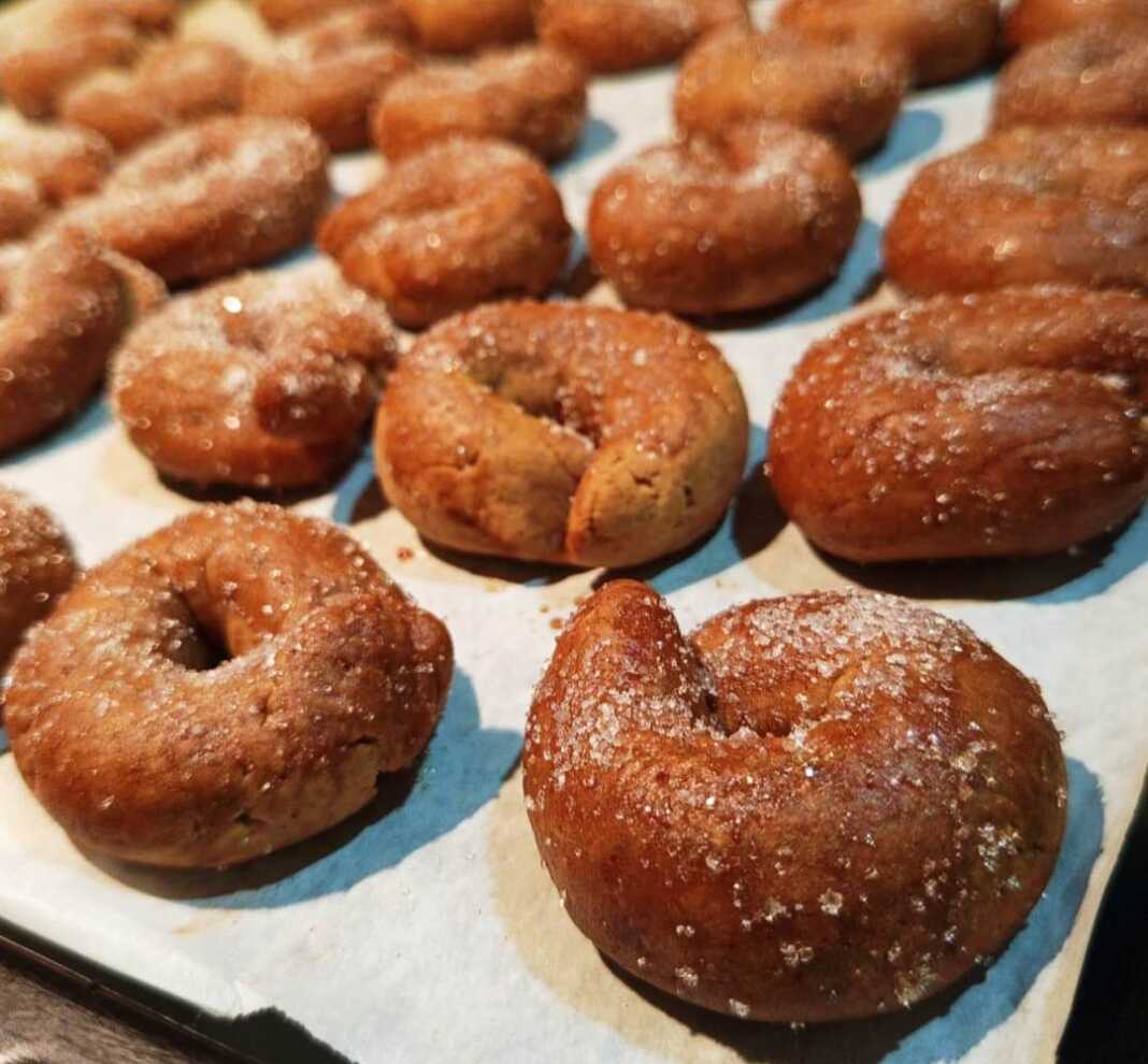 Παραδοσιακά μουστοκούλουρα με πετιμέζι, ψημένα και πασπαλισμένα με ζάχαρη, σε πιατέλα.