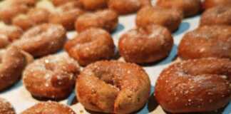 Παραδοσιακά μουστοκούλουρα με πετιμέζι, ψημένα και πασπαλισμένα με ζάχαρη, σε πιατέλα.