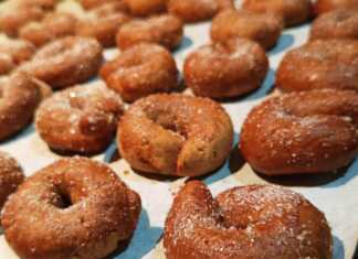 Παραδοσιακά μουστοκούλουρα με πετιμέζι, ψημένα και πασπαλισμένα με ζάχαρη, σε πιατέλα.