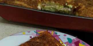 Ενα κομμάτι με χρυσαφένιες Πατάτες Ογκρατέν, με λιωμένο τυρί και φέτες πατάτας, έτοιμο για σερβίρισμα.