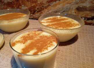 Μπολ με κρεμώδες ρυζόγαλο πασπαλισμένο με άφθονη κανέλα, τοποθετημένο σε ξύλινη επιφάνεια