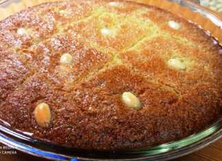 Ένα ταψί με χρυσαφένιο σάμαλι κομμένο σε ρόμβους, γαρνιρισμένο με ολόκληρα αμύγδαλα και πλούσιο σιρόπι που γυαλίζει