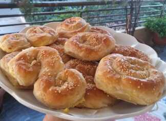 Χρυσαφένιες στριφτές τυρόπιτες σε σχήμα σπιράλ πασπαλισμένες με σουσάμι και ψημένες στον φούρνο