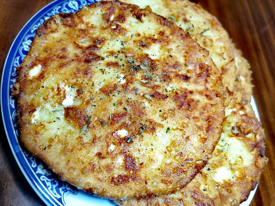 Τέσσερις **Τηγανίτες με Φέτα** σε πιάτο, πασπαλισμένες με ρίγανη.