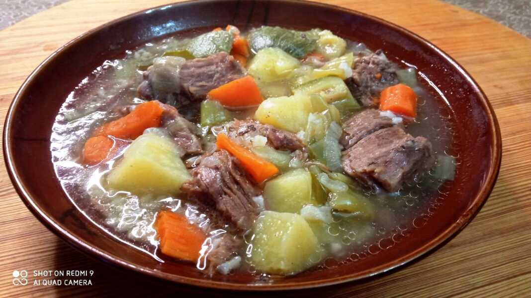 Ζεστό βραστό με μοσχάρι, καρότα και πατάτες, σερβιρισμένο σε βαθύ πιάτο.