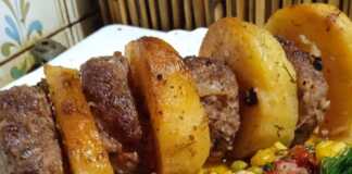 Τα ψημένα **Μπιφτέκια με Αρακά** και πατάτες στο φούρνο, σερβιρισμένα