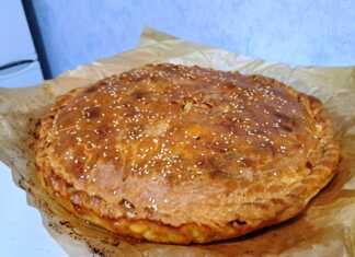 Χρυσαφένια πίτα με γαλοπούλα και πατάτες μέσα σε στρογγυλό ταψί, πασπαλισμένη με σουσάμι.