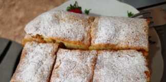 Σπιτικό κέικ γάλακτος πασπαλισμένο με άχνη ζάχαρη σε μια λαδόκολλα.