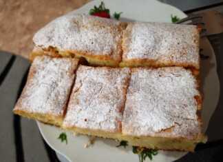 Σπιτικό κέικ γάλακτος πασπαλισμένο με άχνη ζάχαρη σε μια λαδόκολλα.