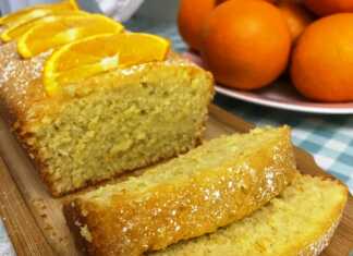 Ένα κομμάτι σιροπιαστού κέικ πορτοκαλιού πασπαλισμένο με ζάχαρη άχνη.