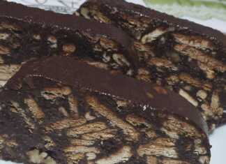 Μακρόστενος κορμός σοκολάτας πασπαλισμένος με κακάο και γεμάτος τραγανά κομμάτια μπισκότου και καρυδιού