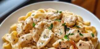 Ένα πιάτο με Κρεμώδες Κοτόπουλο Marsala με Ζυμαρικά, γαρνιρισμένο με φρέσκο μαϊντανό, έτοιμο για σερβίρισμα