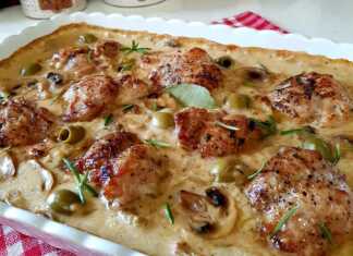 Ψητό κοτόπουλο με μανιτάρια, κρεμμύδια και πράσινες ελιές σε κρεμώδη σάλτσα λευκού κρασιού σε ένα πήλινο σκεύος.