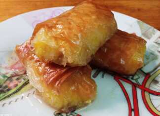 Ατομικά γαλακτομπουρεκάκια σε πιάτο, σιροπιασμένα και τραγανά, με φλούδα πορτοκαλιού.