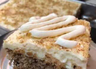 Πλούσιο κομμάτι καρυδόπιτας με παχιά στρώση λευκής κρέμας πασπαλισμένο με κανέλα και καρύδια πάνω σε πιάτο