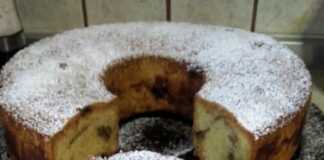 Φωτογραφία με ένα κομμάτι κέικ μήλου πασπαλισμένο με άχνη ζάχαρη.