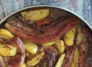 Χοιρινό φούρνου ζουμερό και καλοψημένο, σερβιρισμένο με πατάτες.