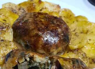 Σαρμάδες με αρνίσια μπόλια και συκωταριά, τοποθετημένοι σε ταψί με φέτες πατάτας, με χρυσαφένια κρούστα από το ψήσιμο.