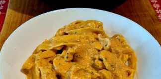 Πιάτο με ταλιατέλες, κοτόπουλο και κρεμώδη σάλτσα πέστο λιαστής ντομάτας, πασπαλισμένο με βασιλικό.