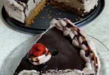 Τούρτα με μπισκοτένια βάση και σοκολάτα Τούρτα σοκολάτας με μπισκοτένια βάση, πλούσια κρέμα και γκανάζ σοκολάτας, διακοσμημένη με κρέμα και κερασάκια.