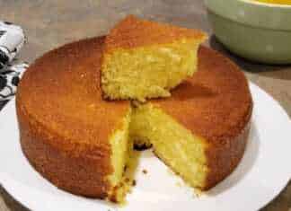 Ένα ψηλό και καλοψημένο κέικ λεμονιού μέσα σε κλασική φόρμα με τρύπα αχνιστό και έτοιμο για σερβίρισμα