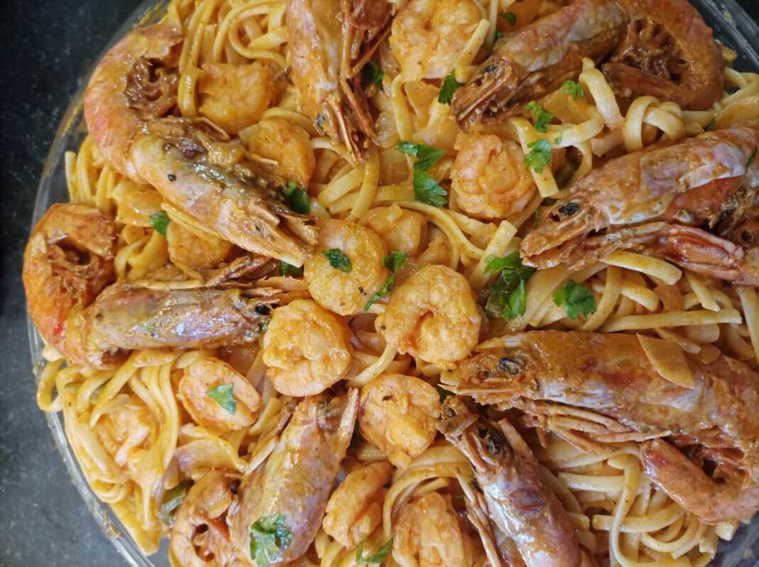 garidomakaronada toumpano Πιάτο με λαχταριστή γαριδομακαρονάδα, με κόκκινη σάλτσα, λιγκουίνι, ψιλοκομμένο μαϊντανό και ολόκληρες γαρίδες από πάνω.