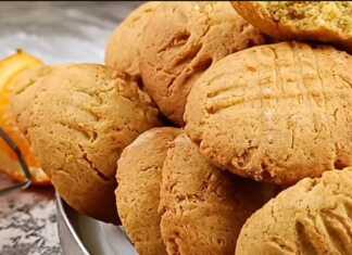 Δίσκος με χρυσαφένια νηστίσιμα κουλουράκια πορτοκαλιού, με σχέδια από πιρούνι στην επιφάνεια, τοποθετημένα πάνω σε λαδόκολλα