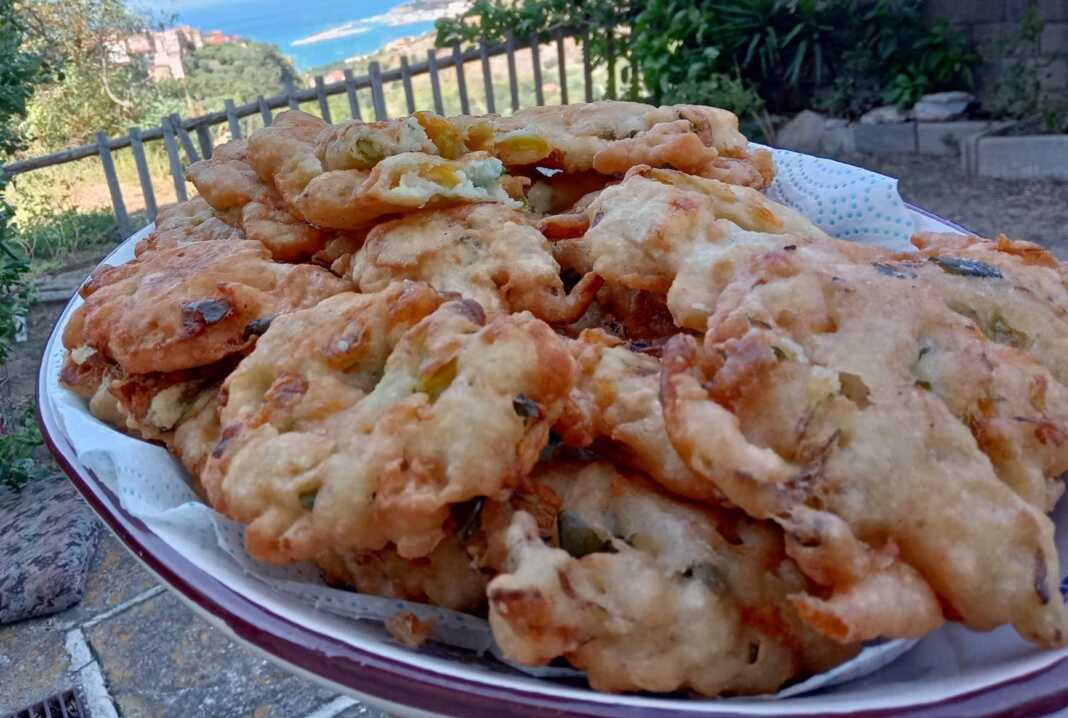 tiganites kolokithoanthous Φωτογραφία με χρυσαφένιες τηγανίτες κολοκυθοανθών σε πιάτο.