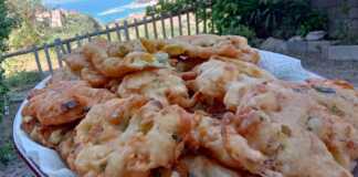 Φωτογραφία με χρυσαφένιες τηγανίτες κολοκυθοανθών σε πιάτο.