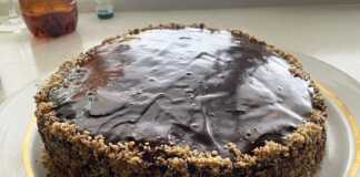 Μια στρογγυλή τούρτα με σταφίδες και καρύδια σε μια πιατέλα.