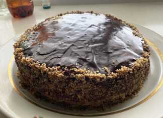 Μια στρογγυλή τούρτα με σταφίδες και καρύδια σε μια πιατέλα.