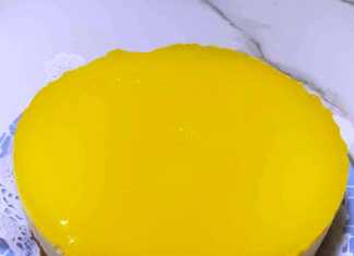 Φωτογραφία μιας λαχταριστής τούρτας λεμονιού με γυαλιστερή κίτρινη επικάλυψη.