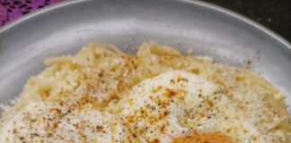 Πιάτο με μακαρόνια ανακατεμένα με μυζήθρα και από πάνω τηγανητά αυγά πασπαλισμένα με μυζήθρα και πάπρικα.