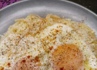 Πιάτο με μακαρόνια ανακατεμένα με μυζήθρα και από πάνω τηγανητά αυγά πασπαλισμένα με μυζήθρα και πάπρικα.