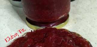 Βάζο με σπιτική κόκκινη μαρμελάδα φράουλα, με ορατά κομμάτια φρούτων, δίπλα σε φρέσκες φράουλες.