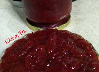 Βάζο με σπιτική κόκκινη μαρμελάδα φράουλα, με ορατά κομμάτια φρούτων, δίπλα σε φρέσκες φράουλες.